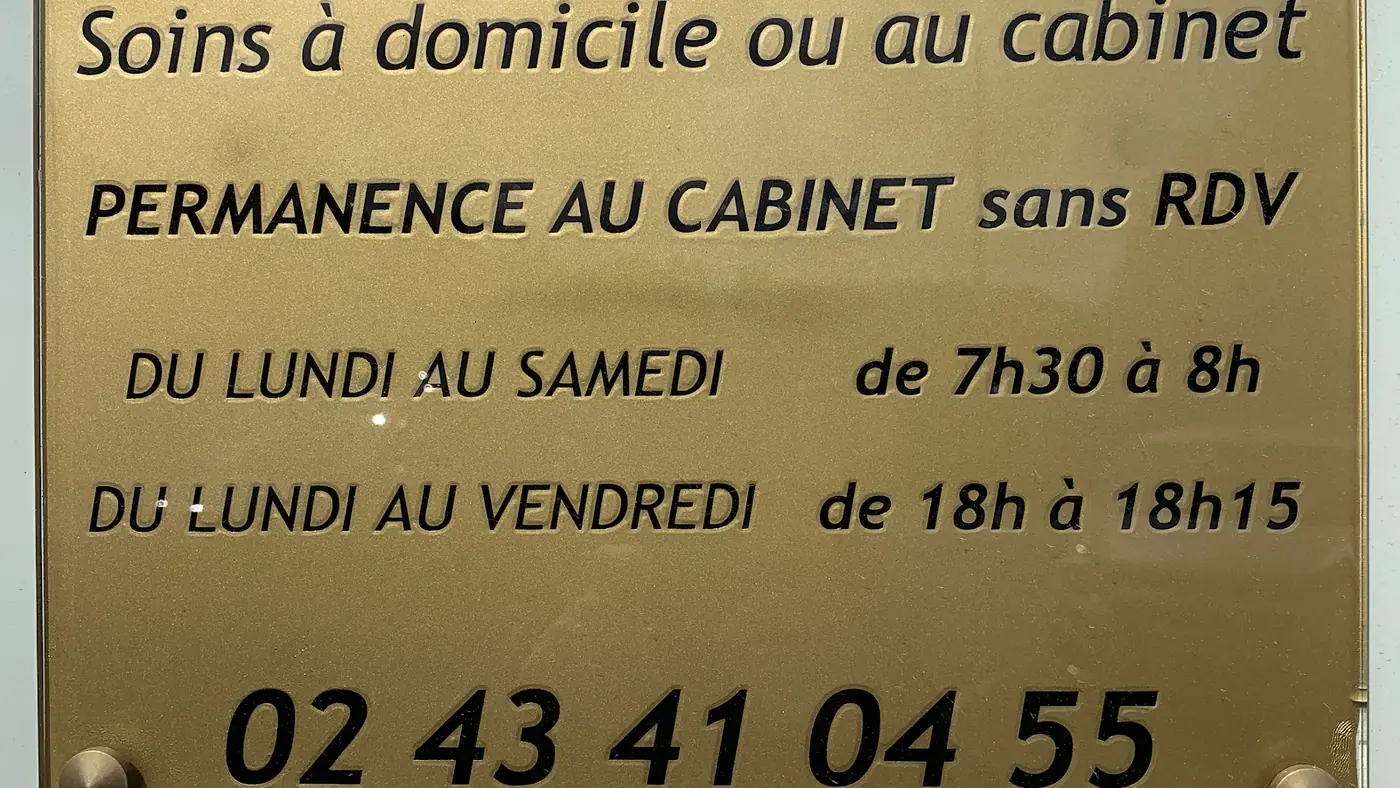 La plaque en laiton du cabinet : soins à domicile ou au cabinet, permanence sans rendez-vous du lundi au samedi de 7h30 à 8h et du lundi au vendredi de 18h à 18h15, 02 43 41 04 55.